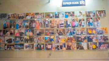 Paret de fotografies en una habitació amb un cartell que diu 'ESPAÇO CLICK'.