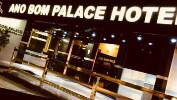 The exterior of Ano Bom Palace Hotel with a prominent sign and entrance.