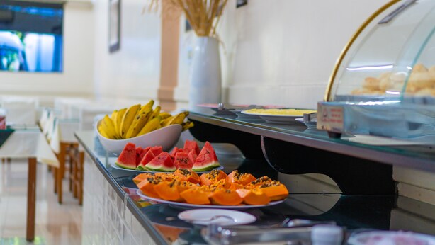 Un bufé con diversas frutas y pasteles.