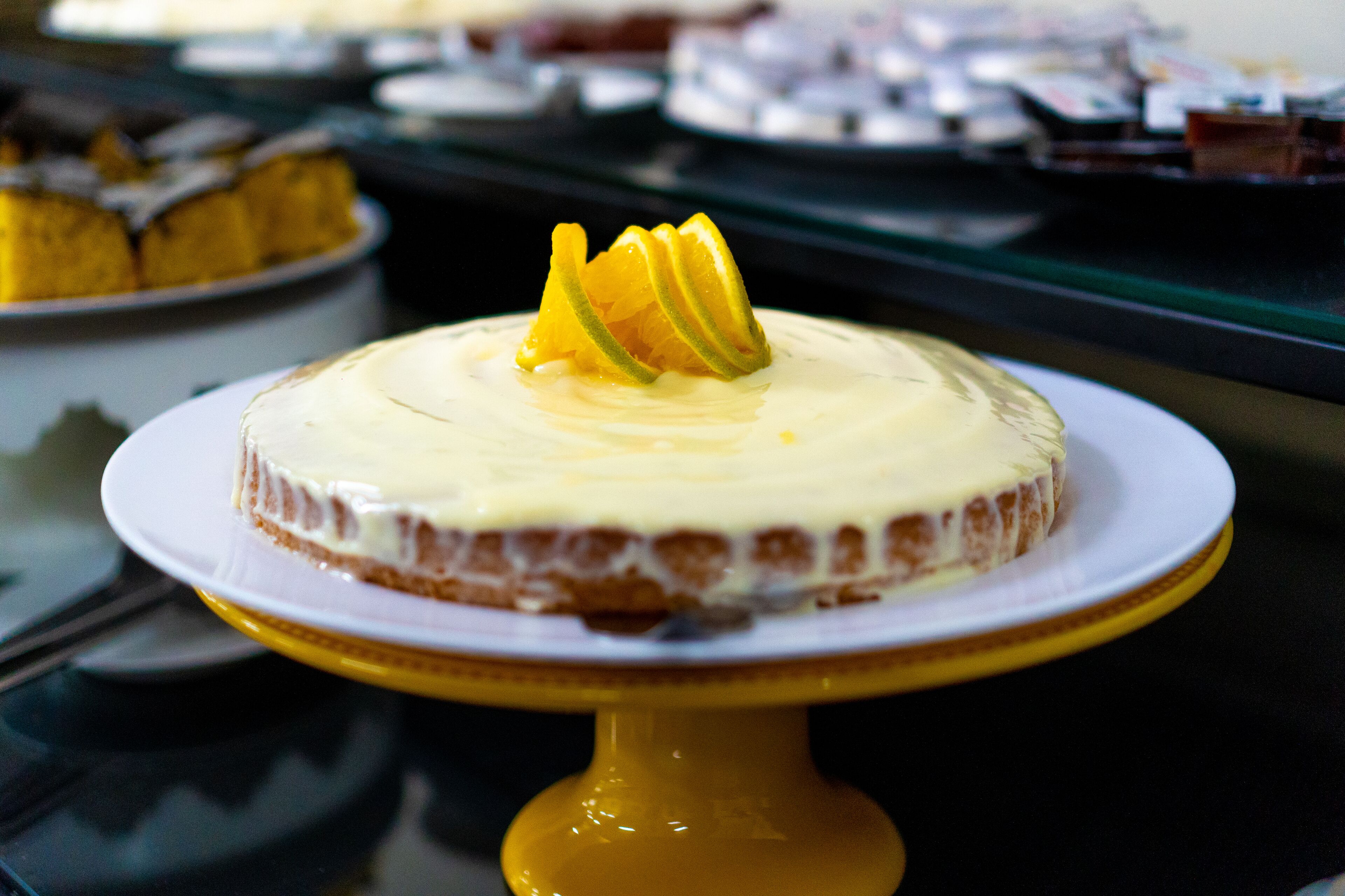 Um bolo com base amarela sobre um suporte amarelo.