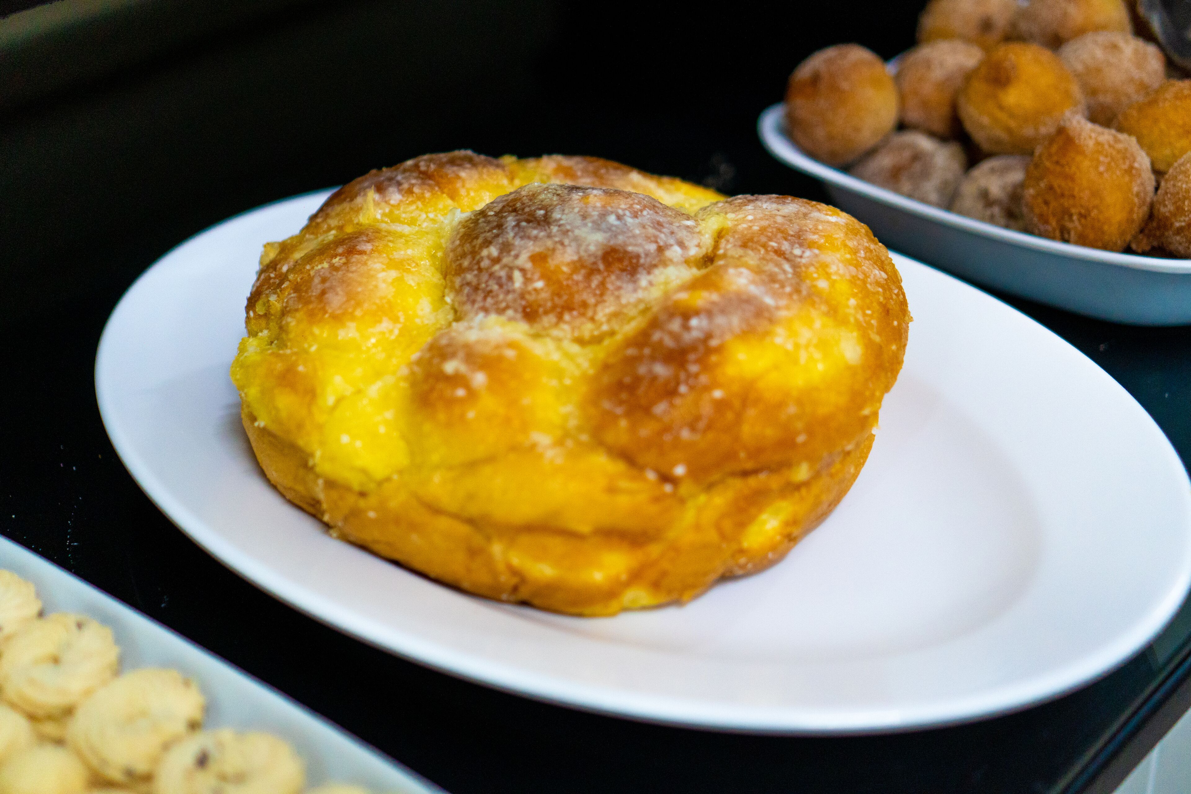 Un plato de pasteles dorados sobre una fuente blanca.