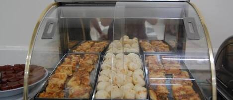 A display case with various baked goods, including pies and pastries, in a bakery or cafe setting.