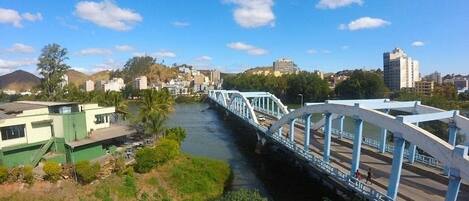 Un río con un puente, edificios y vegetación.