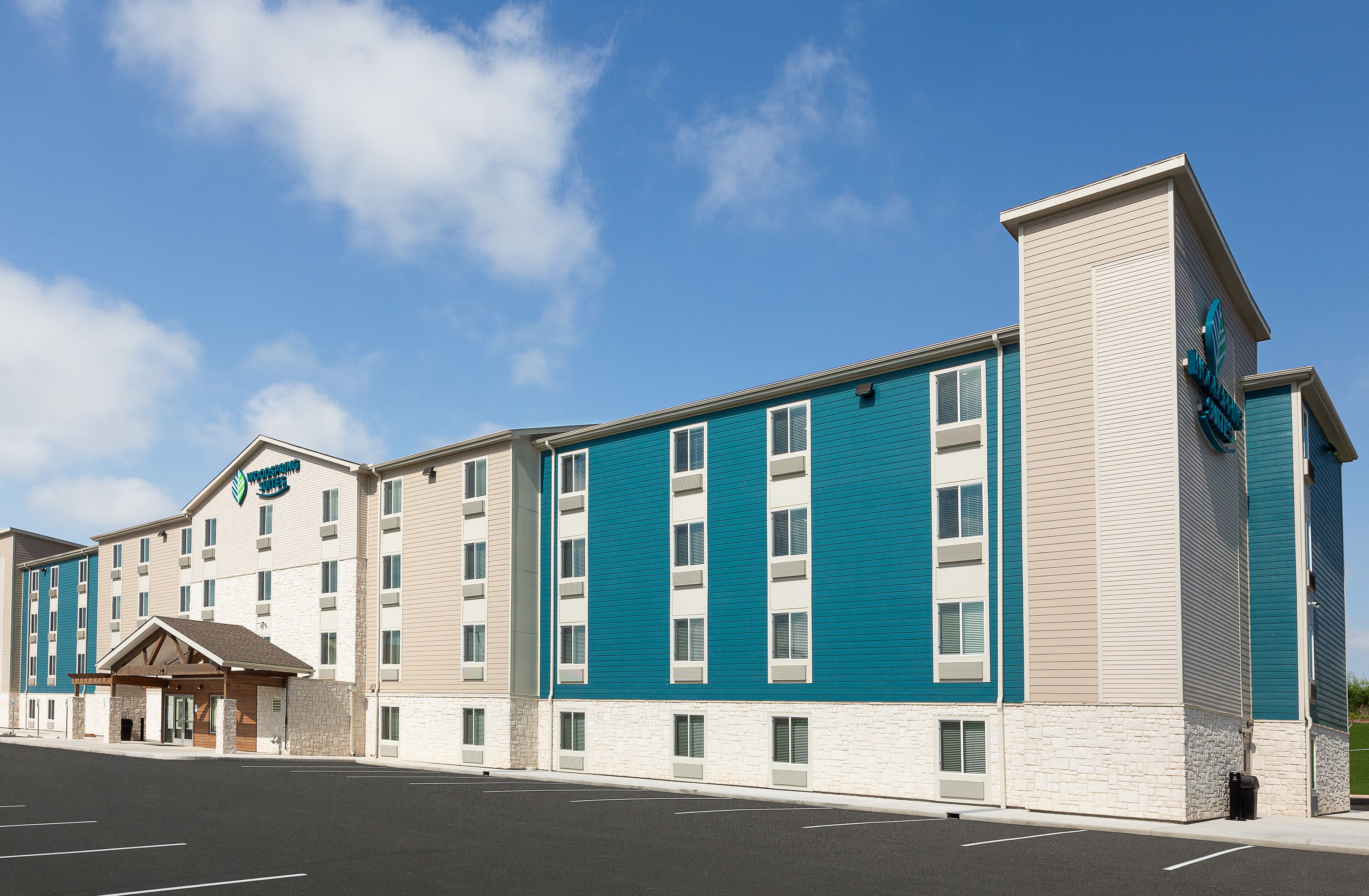 Un hôtel à plusieurs étages, doté d’un design moderne, avec une entrée imposante et un parking situé à l’avant.