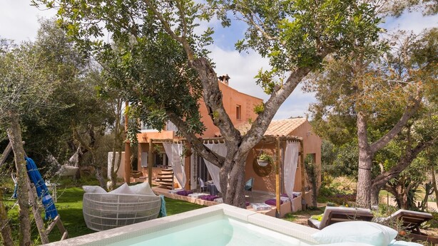 A pool area with lounge chairs and a pergola.
