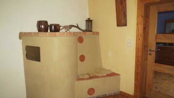 Una habitación de esquina con chimenea integrada, una puerta de madera y un pequeño estante con adornos.