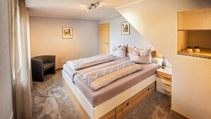 Une chambre à coucher comprenant un lit, des tables de chevet, une chaise et un petit bureau.