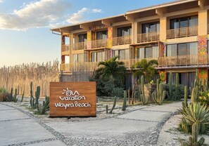 Un hotel de varios pisos con un letrero que dice 'Vacation Wayra Beach'.