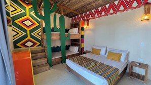 A room with a bunk bed, a colorful geometric wall pattern, a wooden ceiling, and a small bedside table. - Hotel Wayira Beach by On vacation (Manaure)