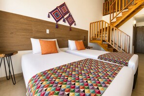 A hotel room with two beds, a wooden headboard, a staircase, and a colorful geometric-patterned bedspread. - Hotel Wayira Beach by On vacation (Manaure)
