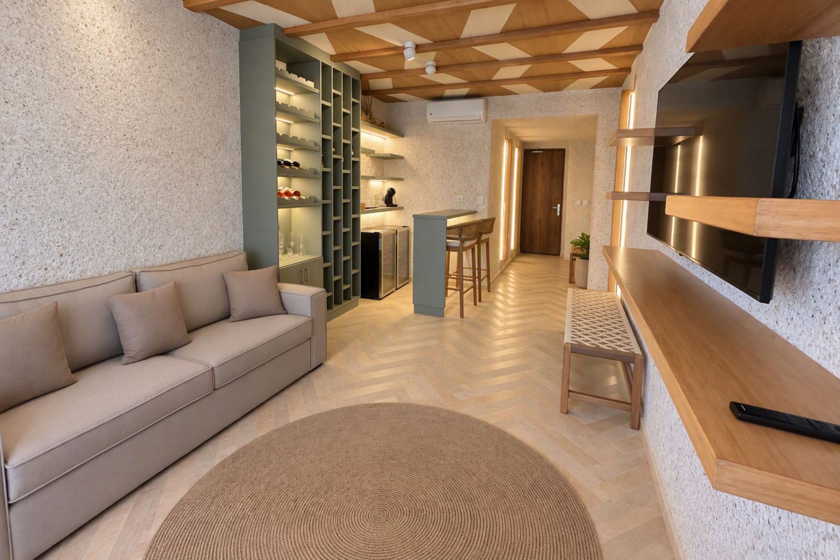 Una sala de estar moderna con un sofá, una mesa de centro, un televisor y una estantería.