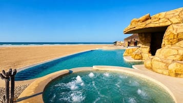 Una piscina al aire libre, sombrillas, sillones reclinables de piscina