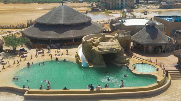 Una piscina al aire libre, sombrillas, tumbonas