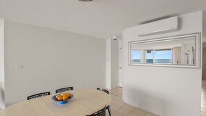 Ein Essbereich mit einem runden Tisch, Stühlen und einer Obstschale.