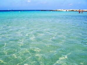 Clear turquoise water at a beach with a rocky shoreline and a few people in the distance. - House / Villa - Diso (Diso)