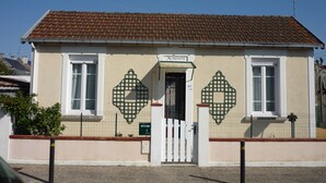 Ein Gebäude mit Ziegeldach, heller Fassade und einem Schild mit der Aufschrift "Mimosette".