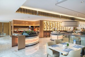 Un restaurant moderne doté d’un îlot central, d’un espace salon et offrant une vue sur la cuisine.