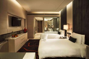 A hotel room with a bed, a desk, a TV, a mirror, and a bathroom visible through an open door. - Hilton Xi'an High-tech Zone (Xi'an)