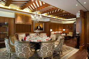A formal dining room with a round table, ornate chairs, and a chandelier. - Hilton Xi'an High-tech Zone (Xi'an)