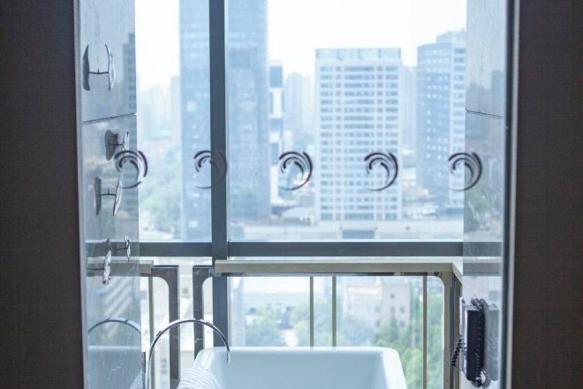 A view from a window with a metal railing, a white sink, and a telephone.