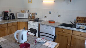 A kitchen with a microwave, stove, and dishwasher. There are wooden cabinets and a granite countertop.
