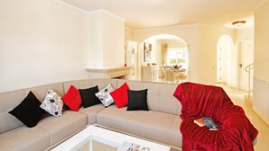 A living room with a beige sofa, a red blanket, and a white coffee table. - Townhouse pool and jacuzzi in Portimão (Portimão)