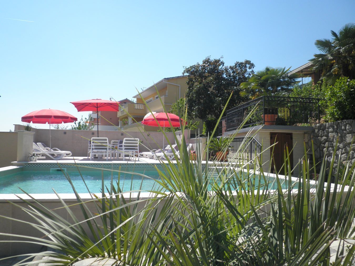 Alberca al aire libre y camastros 