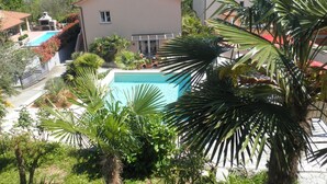 Un quartier résidentiel doté d’une piscine, de palmiers et offrant une vue sur la mer.