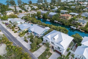 Vista aérea de una zona residencial con casas, un puerto deportivo y una masa de agua azul y cristalina.
