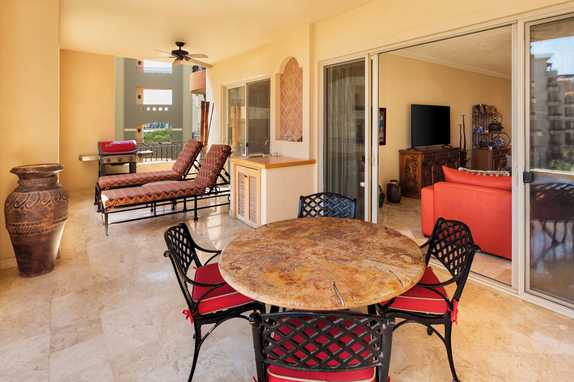A dining area with a round table and chairs, a sofa, and a TV.