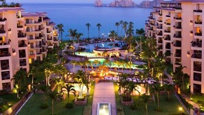 A resort with multiple buildings, a central pool area, and a view of the ocean. - Premium Direct View - Extra Large Terrace - Medano Beachfront! (Cabo San Lucas)