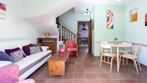 Ein Wohnzimmer mit Sofa, Couchtisch und einem Essbereich mit Stühlen und Tisch.