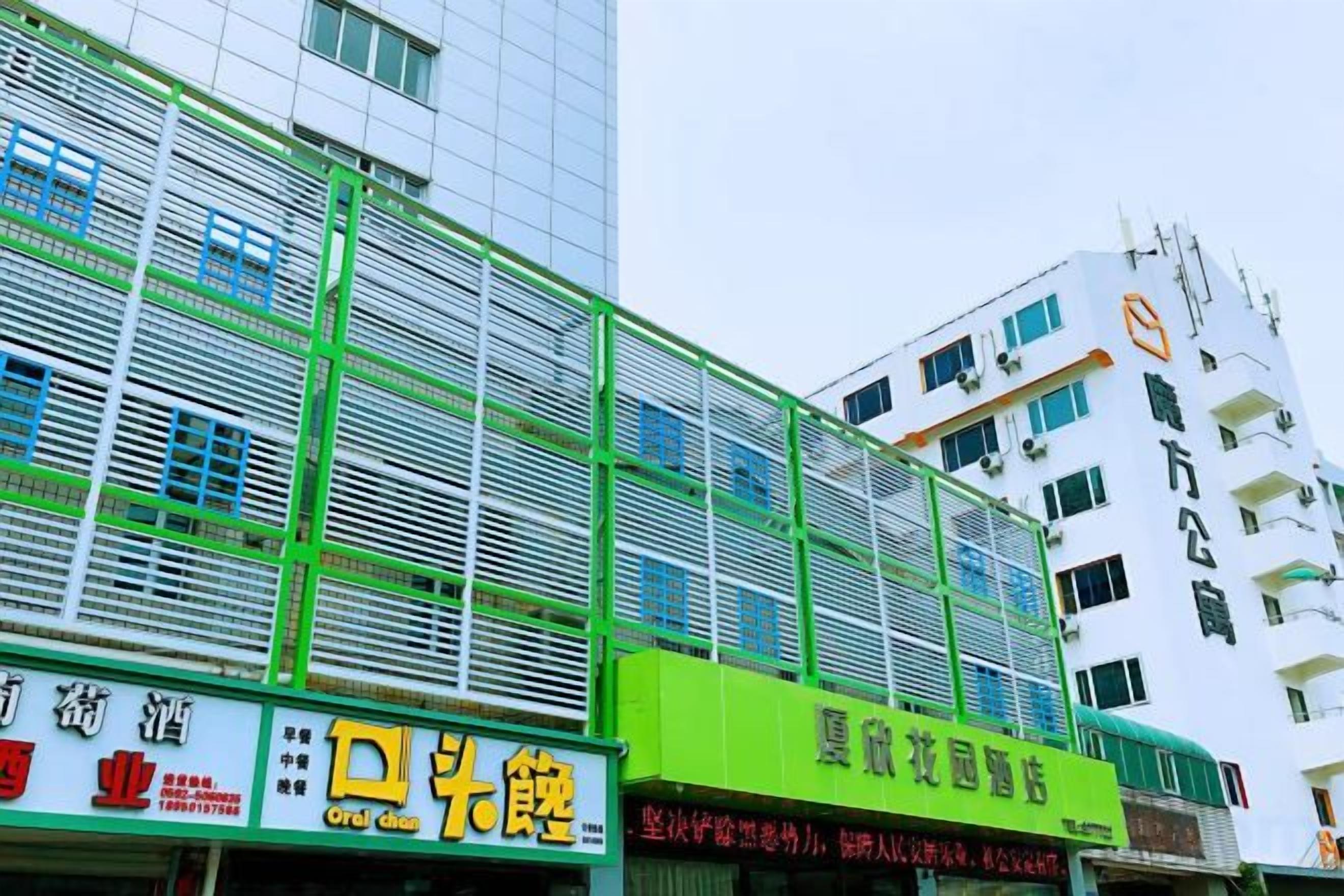 Un edificio de varios pisos con locales comerciales en la planta baja, incluyendo un restaurante y una floristería.