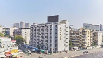 A multi-story hotel with a flat facade, located in an urban setting with other buildings in the background.