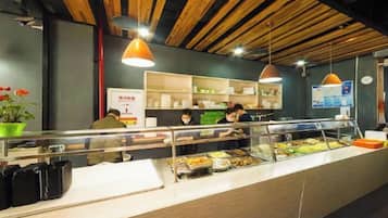 A buffet area with a counter, food display, and seating area.