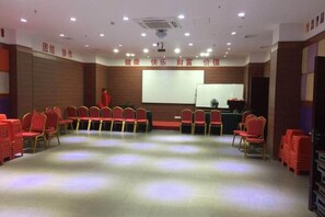 A conference room with rows of chairs, a projector screen, and a presentation area. - GreenTree Alliance Hotel (Xiamen Railway Station Sports Center) (Xiamen)