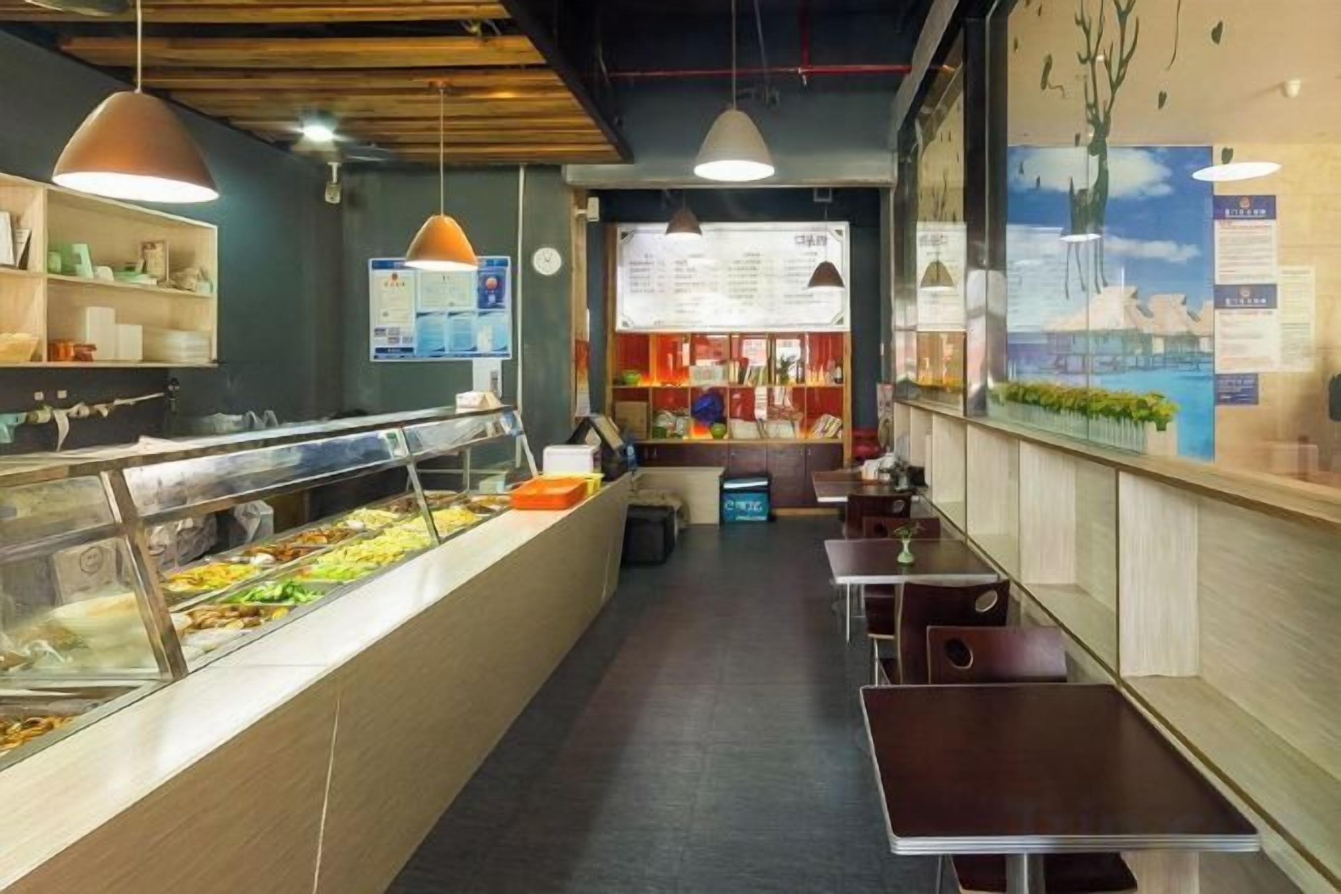 A restaurant interior with a buffet counter, seating area, and menu board.