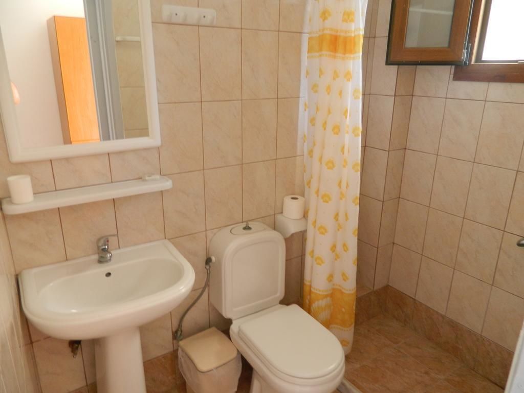 Ein Badezimmer mit Waschbecken, Toilette und Duschvorhang.