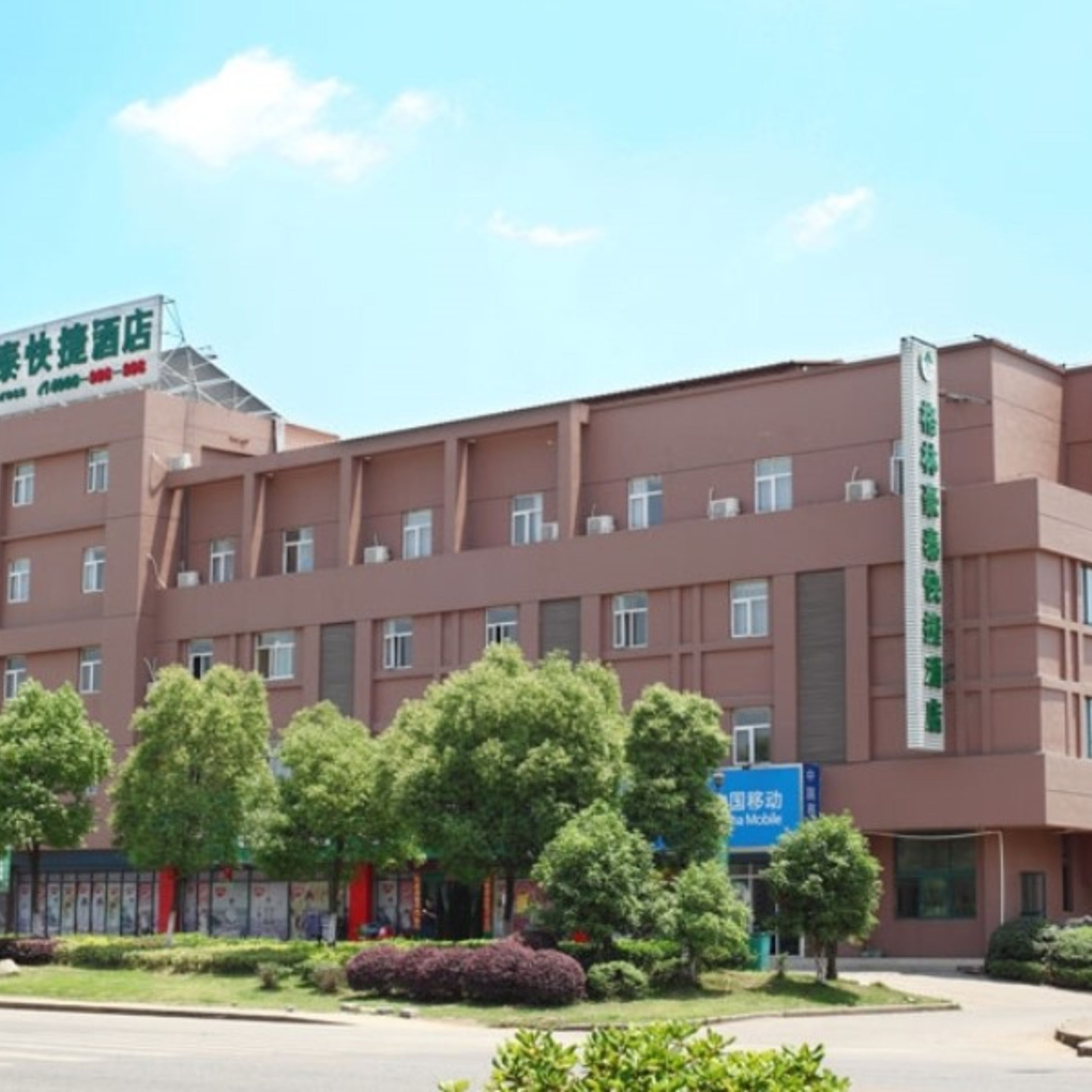 Un edificio de varios pisos con techo plano y un cartel en la parte superior.