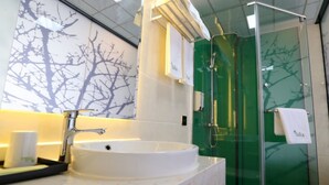 A bathroom with a white sink, a mirror, a glass shower enclosure, and a toilet. - Vatica Shanghai Jinshan District Jinshan Guojishangmaocheng Weihong Road Hotel (Shanghai)