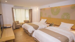 A hotel room with two beds, a desk, a chair, and a small table.