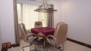 A dining area with a table, chairs, and a ceiling light fixture.