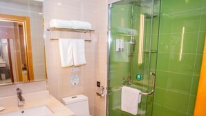 A bathroom with a sink, toilet, and a glass-enclosed shower area.