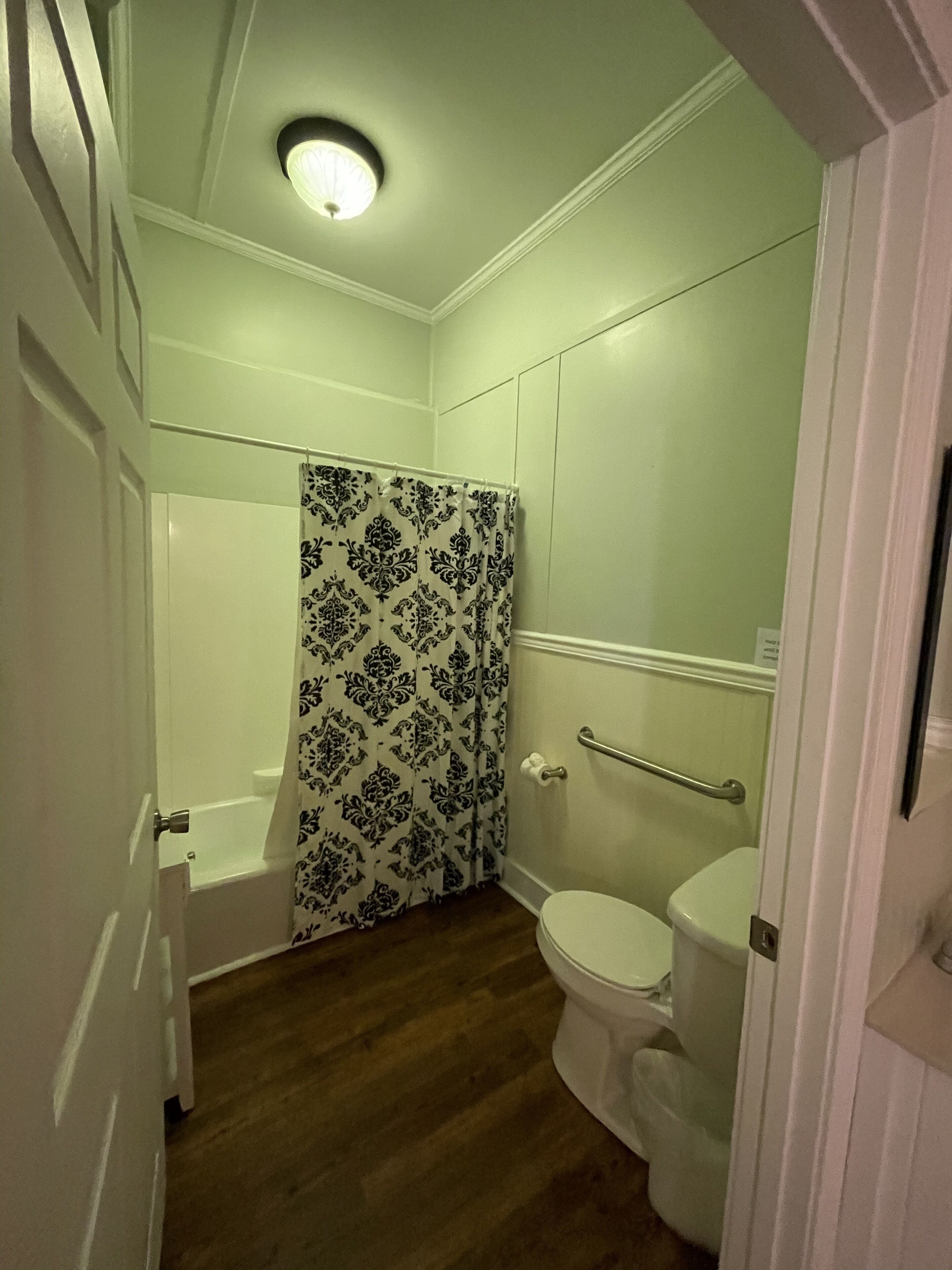 A bathroom with a bathtub, toilet, and a shower curtain.