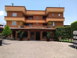 A multi-story building with a reception lobby, spa, restaurant, and parking area.