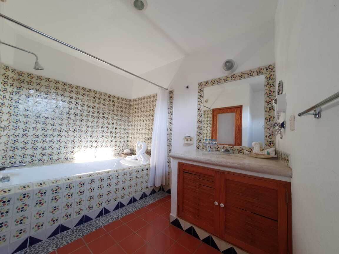 Ein Badezimmer mit Badewanne, Waschbecken und einem Waschtisch mit Spiegel.