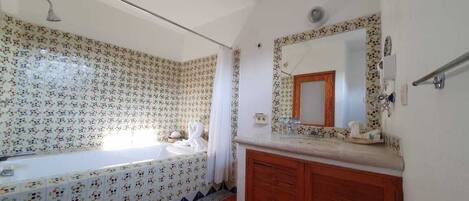 Ein Badezimmer mit Badewanne, Waschbecken und einem Waschtisch mit Spiegel.