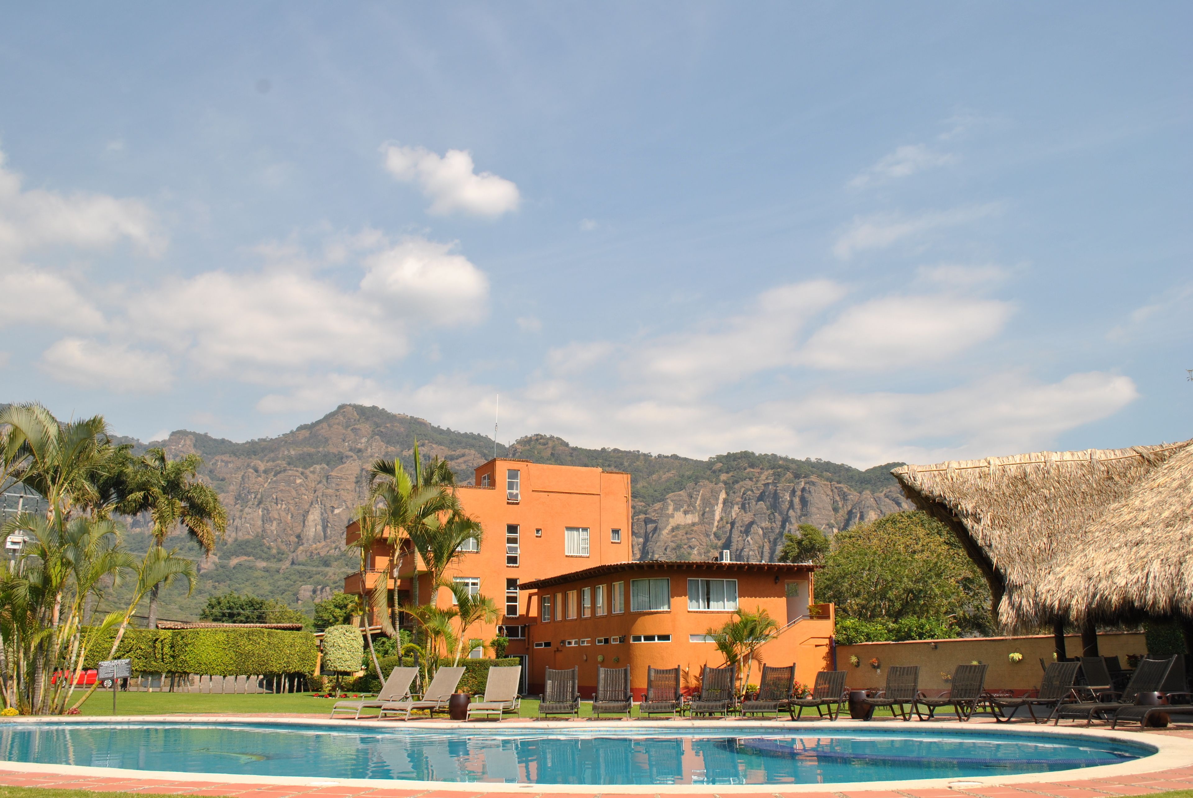 Ein Hotel mit Pool, Liegestühlen und Bergblick.