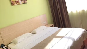 A hotel room with a bed, a nightstand, a painting on the wall, and a window with curtains. - GreenTree Inn Shanghai Songjiang District Sijing Town Sijing Metro Station Express Hotel (Shanghai)