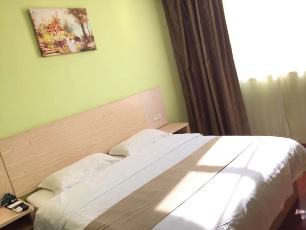 A hotel room with a bed, a nightstand, a painting on the wall, and a window with curtains. - GreenTree Inn Shanghai Songjiang District Sijing Town Sijing Metro Station Express Hotel (Shanghai)